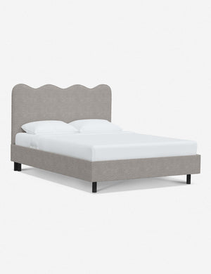 Angled view of Clementine moonlight boucle platform bed with undulating lined headboard