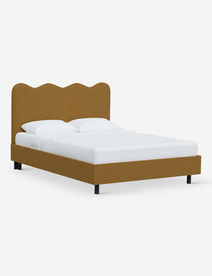 Angled view of Clementine ochre boucle platform bed with undulating lined headboard