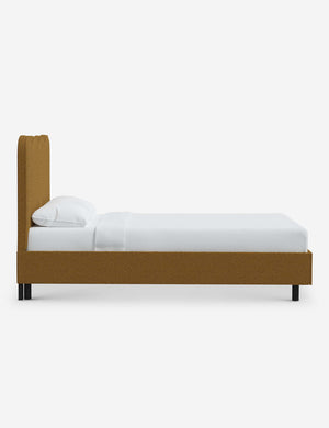 Side view of Clementine ochre boucle platform bed with undulating lined headboard