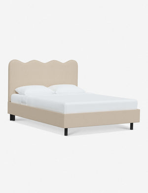 Angled view of Clementine natural linen platform bed with undulating lined headboard
