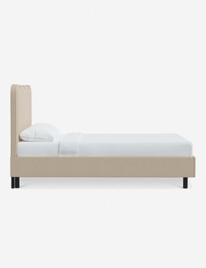 Side view of Clementine natural linen platform bed with undulating lined headboard