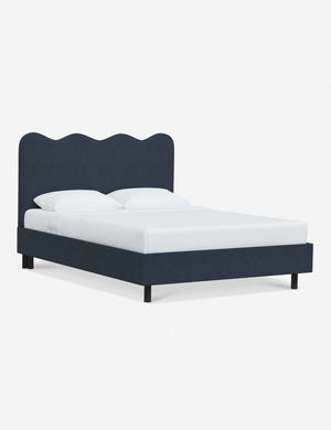 Angled view of Clementine navy linen platform bed with undulating lined headboard