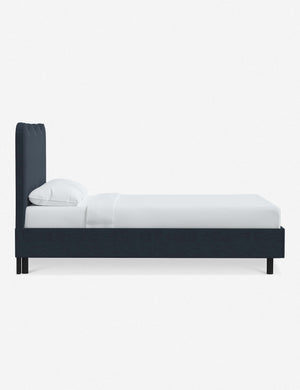 Side view of Clementine navy linen platform bed with undulating lined headboard