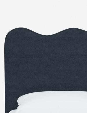 Close-up of the undulating lines on the headboard of the Clementine navy linen platform bed