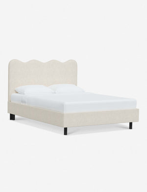 Angled view of Clementine talc linen platform bed with undulating lined headboard