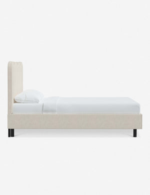 Side view of Clementine talc linen platform bed with undulating lined headboard