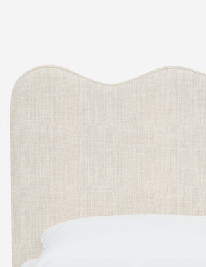 Close-up of the undulating lines on the headboard of the Clementine talc linen platform bed