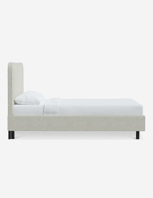 Side view of Clementine white boucle platform bed with undulating lined headboard