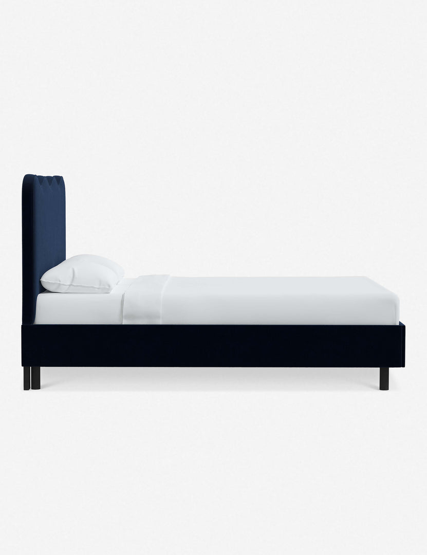 #color::navy-velvet #size::twin #size::full #size::queen #size::king #size::cal-king | Side view of Clementine navy velvet platform bed with undulating lined headboard