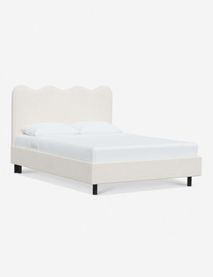 Angled view of Clementine cream sherpa platform bed with undulating lined headboard