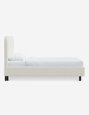 Side view of Clementine cream sherpa platform bed with undulating lined headboard