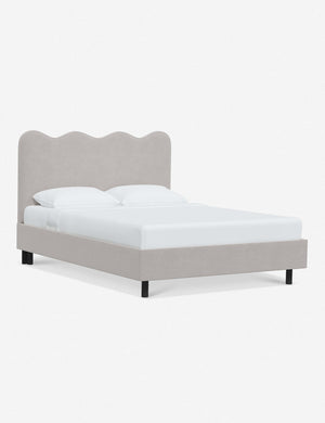 Angled view of Clementine mineral velvet platform bed with undulating lined headboard