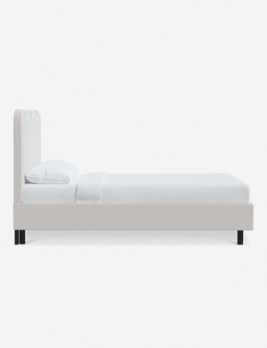 Side view of Clementine snow velvet platform bed with undulating lined headboard