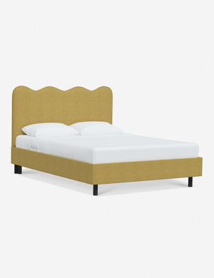 Angled view of Clementine golden linen platform bed with undulating lined headboard