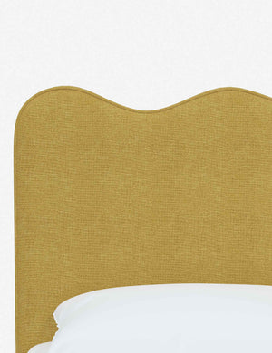 Close-up of the undulating lines on the headboard of the Clementine golden linen platform bed