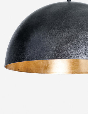 Close-up of the left side of the Sigmund black pendant light with a gold-leaf interior by Regina Andrew