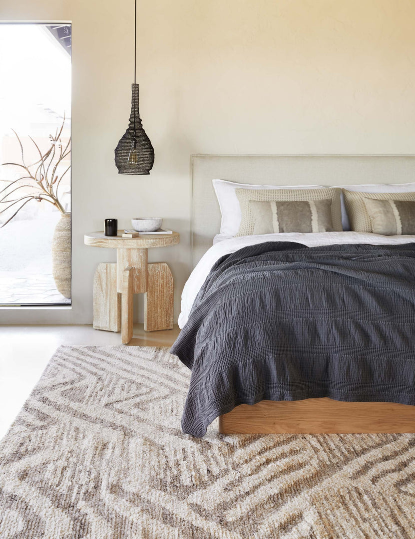 #color::midnight #size::king #size::queen #size::twin | The Nantucket Cotton Matelassé midnight grey Coverlet by Pom Pom at Home lays on a natural linen framed bed in a bedroom with a black jute pendant light and patterend rug
