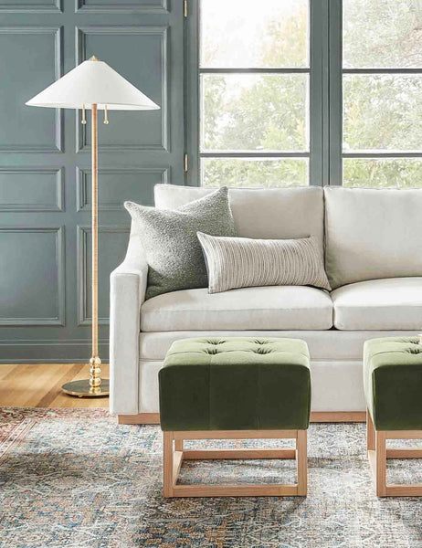 #color::moss #size::20--x-20- | The Manon linen moss green square boucle pillow sits on a white sofa in a living room with green accented walls and green velvet ottomans