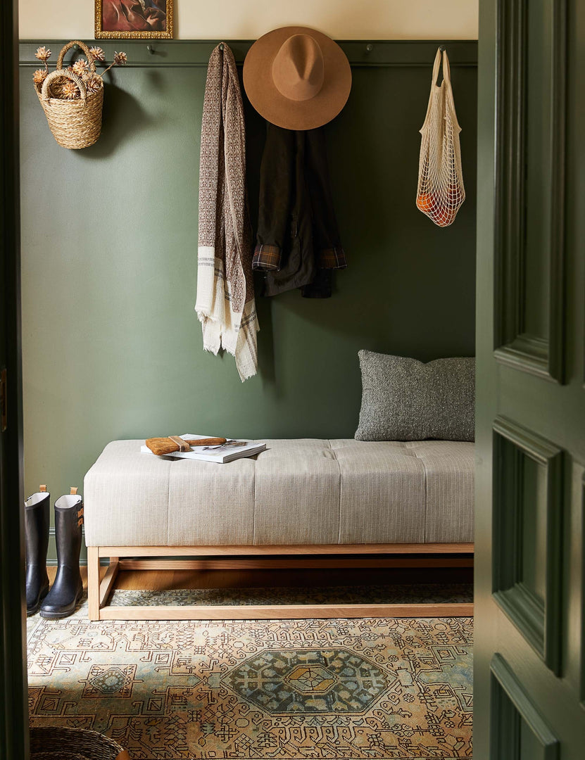#color::stripe | The Grasmere natural stripe linen wooden bench sits in an entry way with green painted walls and a patterned rug