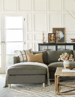 The Belmont left-facing loden gray linen sectional sits atop a gray and white patterned carpet in a room with accented walls