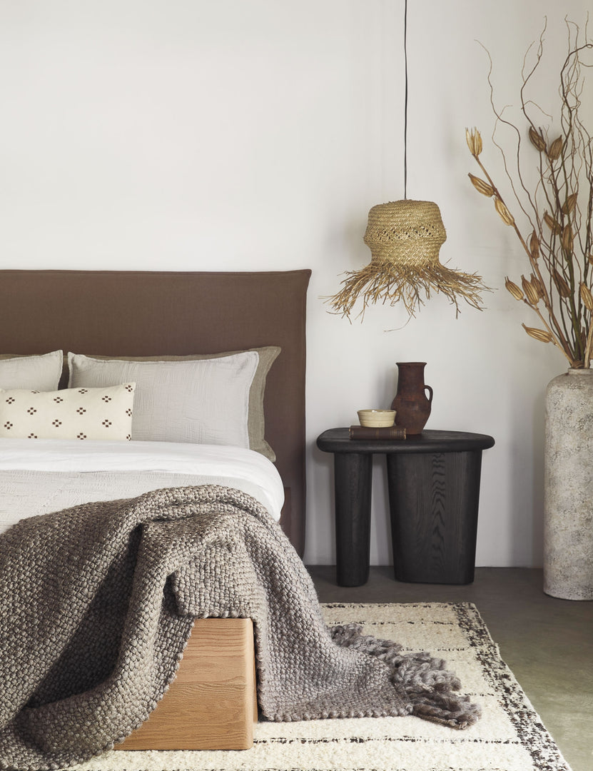 #color::taupe #size::king #size::queen #size::twin | The Harbour Cotton Matelassé taupe Coverlet by Pom Pom at Home with geometric woven texture sits on a brown linen framed bed in a bedroom with a jute pendant light and a sculptural black nightstand 