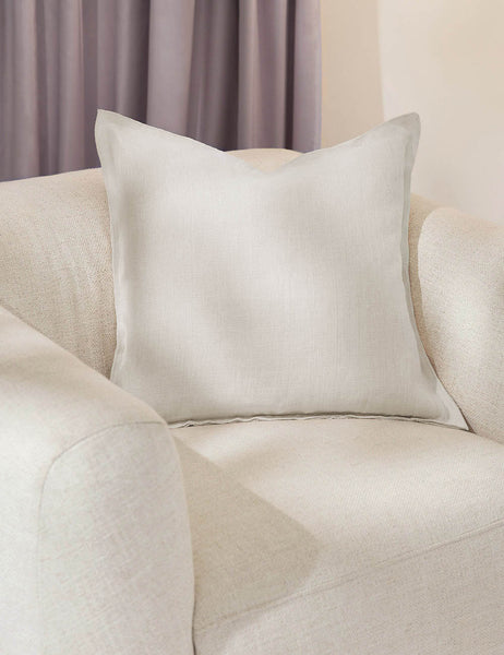 #color::ivory #style::square | The arlo ivory square pillow sits in a studio room on a white linen accent chair