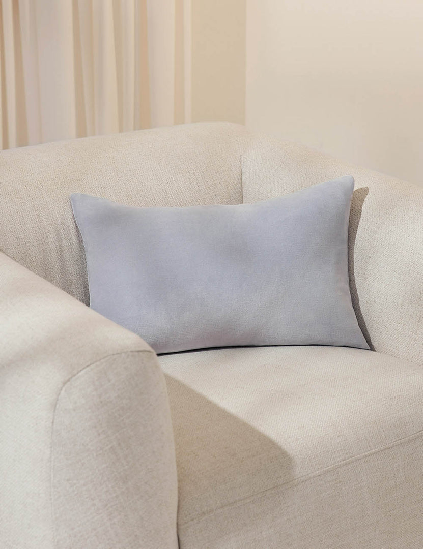 #color::ice-blue #size::13--x-20- #style::lumbar| Charlotte ice blue lumbar velvet pillow sits on a white accent chair with a white curtain in the background