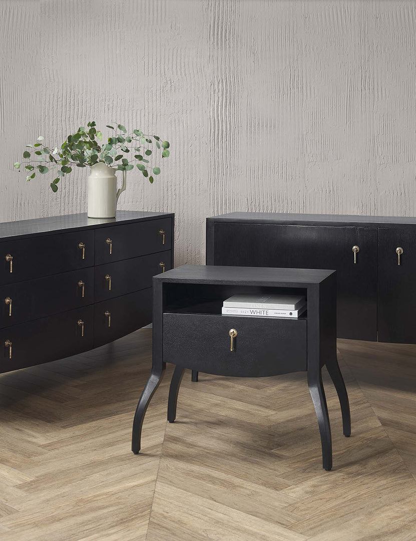 | The Anabella black wood dresser with silver drawer pulls sits in a room with the anabella nightstand and anabella console table.