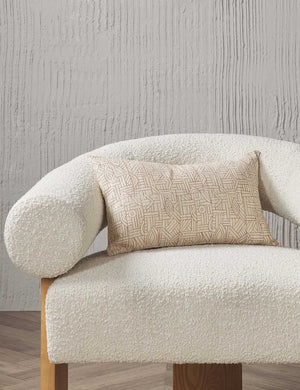 The Kisha natural-toned lumbar throw pillow sits on a cream boucle accent chair in a studio room