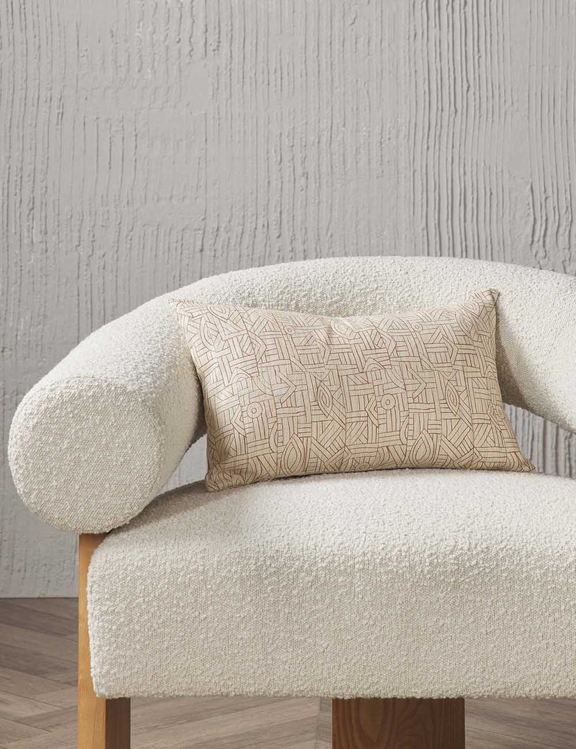#size::12--x-20- | The Kisha natural-toned lumbar throw pillow sits on a cream boucle accent chair in a studio room 