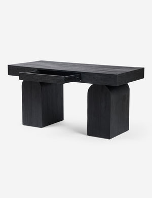 Angled view of the Mags sculptural solid wood desk in black with drawer open.