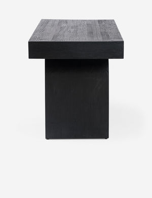 Side view of the Mags sculptural solid wood desk in black.