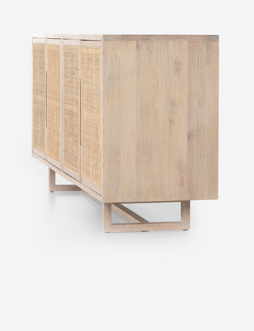 #color::whitewash | Angled side view of the Margot whitewashed natural mango wood sideboard with cane doors.