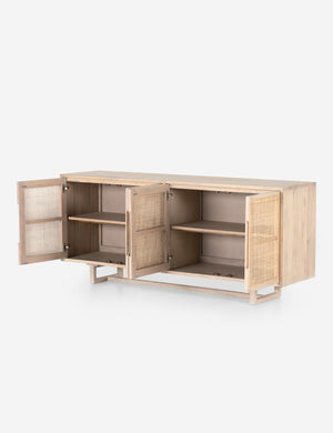 All four doors open on the Margot whitewashed natural mango wood sideboard with cane doors revealing the inner shelving.