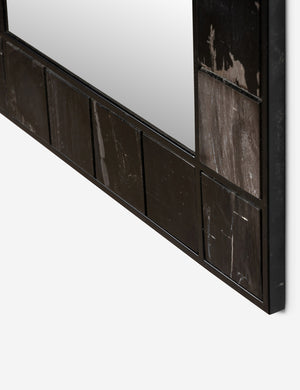Close up angled view of the corner of the iron and petrified wood framed Magna wall mirror