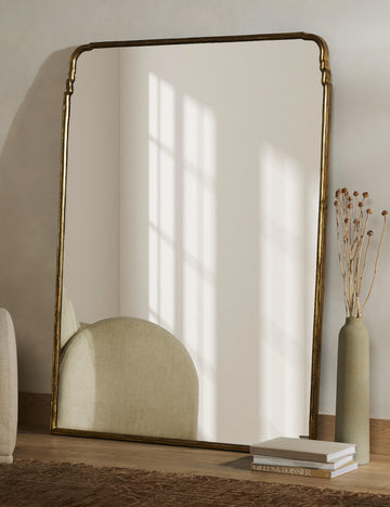 | Teresa thin gold-leaf frame floor mirror styled with a vase full of dried botanicals.