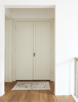 The Line Drawing Flatweave Rug in its two by three feet size lays in a hallway in front of double doors