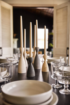 The Pantry wooden candlesticks with smooth curves by farmhouse pottery in gray, neutral, and white sit on a black dining room table