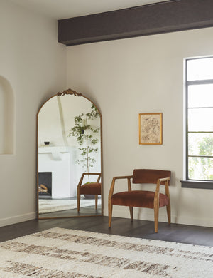 The esha rug lays in the corner of a room with a cognac velvet accent chair and a brass decorative floor mirror