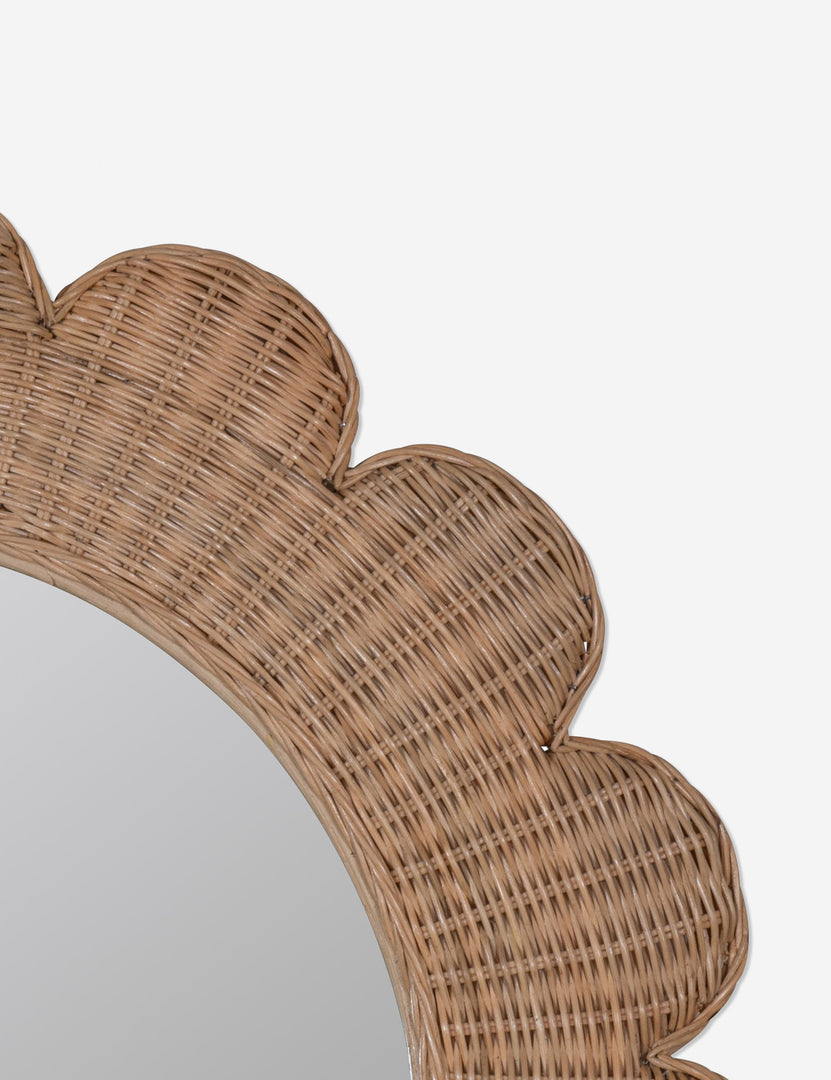 #color::natural | Close up of the corner of the Asha round scalloped wicker framed wall mirror.