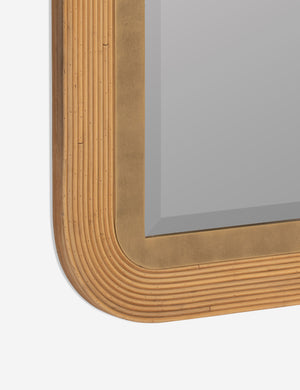 angled view of the rounded bottom corner of the Oona rattan, gold leaf decorative wall mirror
