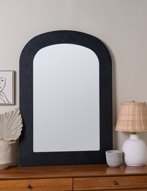arched black wall mirror on top of dresser