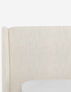 Close-up of the subtle winged headboard and trim lines on the Adara talc linen upholstered bed.