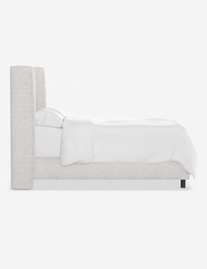 Side view of the Adara white boucle upholstered bed.