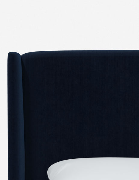 #color::navy-velvet #size::twin #size::full #size::queen #size::king #size::cal-king | Close-up of the subtle winged headboard and trim lines on the Adara navy velvet upholstered bed.