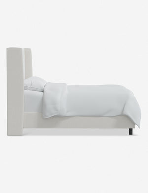 Side view of Adara white velvet upholstered bed.
