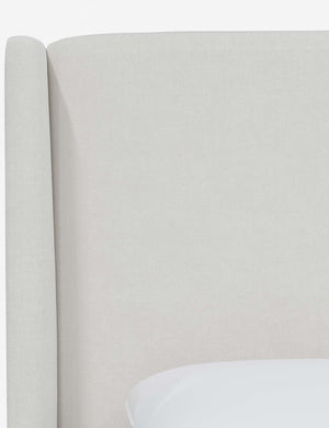 Close-up of the subtle winged headboard and trim lines on the Adara white velvet upholstered bed.