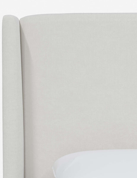 #color::snow-velvet #size::twin #size::full #size::queen #size::king #size::cal-king | Close-up of the subtle winged headboard and trim lines on the Adara white velvet upholstered bed.