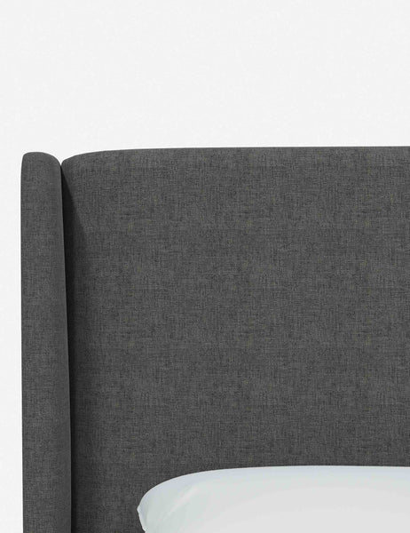 #color::charcoal-linen #size::king | Close-up of the subtle winged headboard and trim lines on the Adara gray linen upholstered bed.