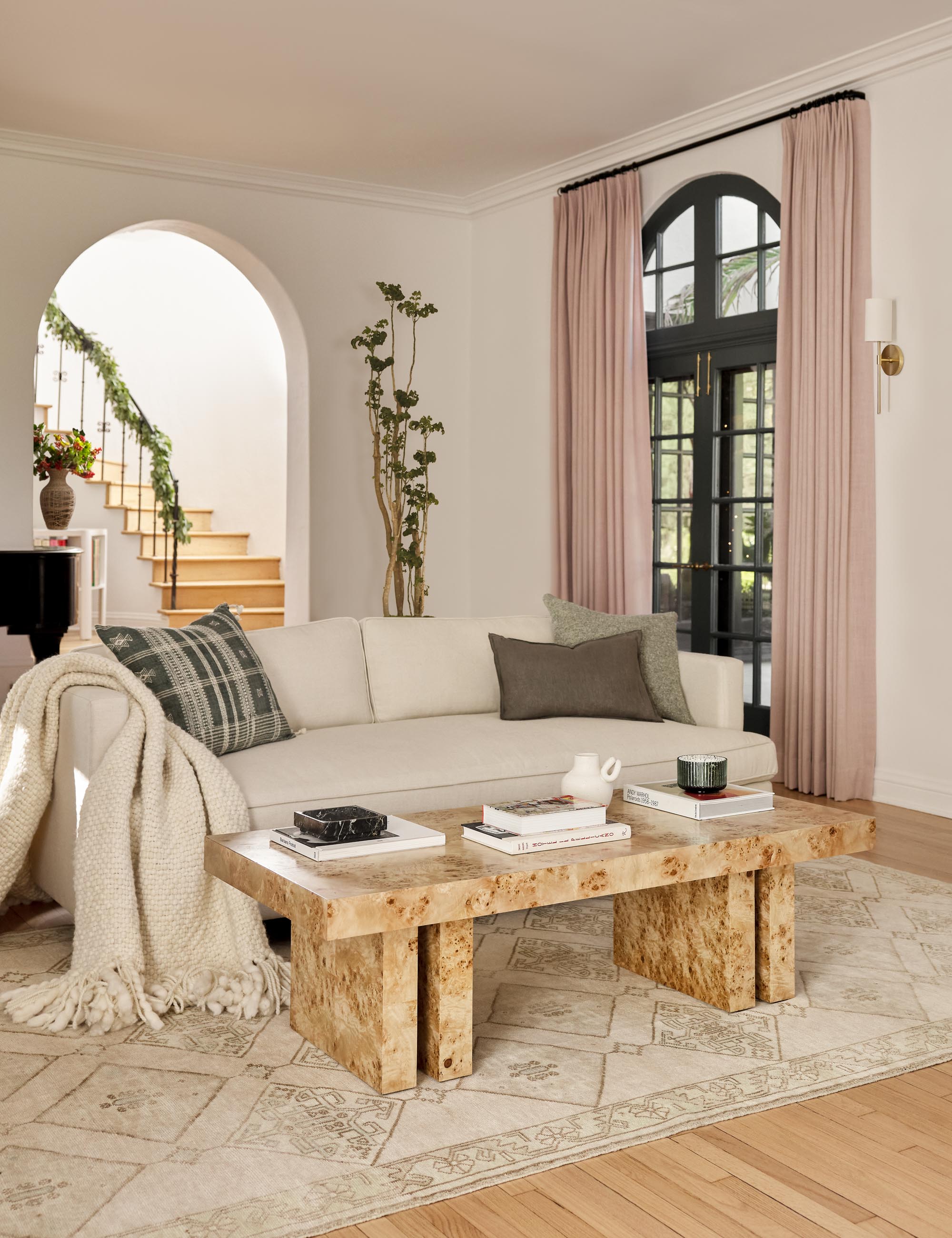 Three-seater sofa in light beige fabric with two back cushions and wooden legs, minimal and contemporary.